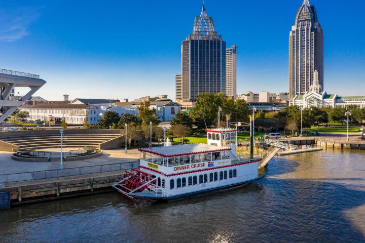 a large boat in a body of water with a city in the background